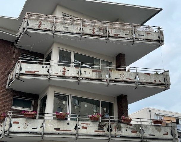 Mehrere Balkone eines modernen Gebäudes mit Blumenkästen und Brüstung.